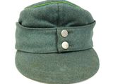 a green hat with buttons on it on a white background