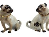 deux figurines de carlins assis l'une à côté de l'autre sur une surface blanche