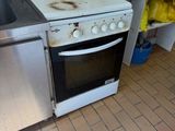 a dirty stove and sink in a dirty kitchen