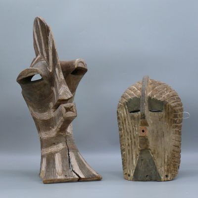 une paire de sculptures en bois représentant une tête d'homme et un visage de femme