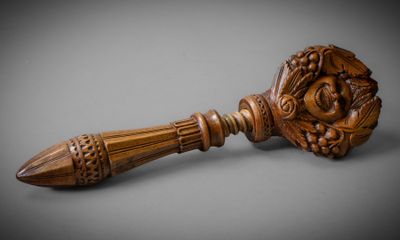 une image représentant un manche en bois sur lequel est dessiné un visage