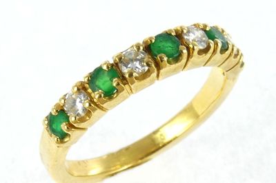 an image of a yellow gold ring with emerald and white diamonds