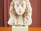 buste en marbre représentant un homme aux cheveux bouclés, posé sur une table en bois