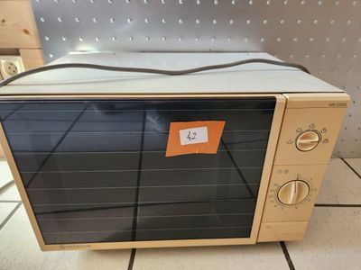un four grille-pain posé sur un carrelage, avec une étiquette de prix dessus