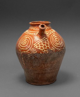 brown and white vase with swirly design on it on a gray surface