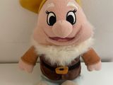 Peluche Disney « Blanche-Neige et les sept nains » posée sur une surface blanche