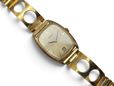 a close up of a gold wrist watch on a white surface