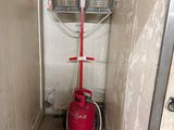 une borne d'incendie rouge dans un coin d'une petite pièce