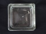 a square glass ashtray on a black cloth