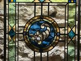a stained glass window in a stone wall