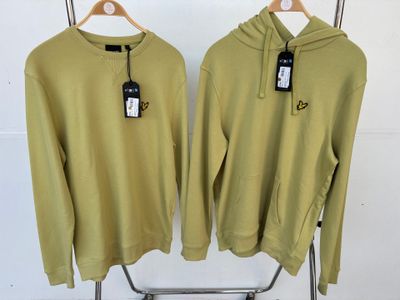 deux sweats verts suspendus à un portant, avec leurs étiquettes encore attachées