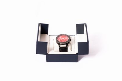 une montre posée dans un coffret sur une surface blanche