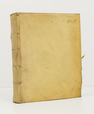 un vieux livre posé sur une table à côté d'un mur blanc
