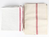 two white and red striped towels sitting on top of each other