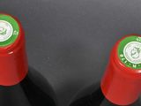 two bottles of wine sitting next to each other on a table