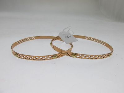 pair of gold tone bang bracelets with green stones on them
