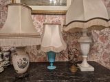 two lamps that are on a table with a picture in the background