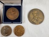 several coins are sitting on a white surface next to a box
