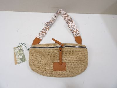 beige straw bag with tan leather handles and a brown leather strap