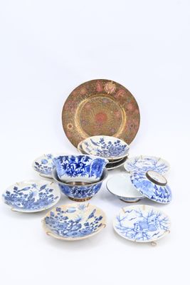 plusieurs assiettes, tasses et soucoupes bleues et blanches posées sur une surface blanche