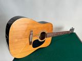 une guitare acoustique posée sur une table verte