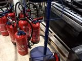 several fire extinguisors are lined up on a pallet in a warehouse