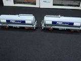 two train cars sitting next to each other on a table