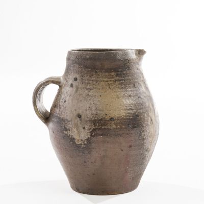 a brown vase that is sitting on a white surface