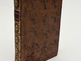 a close up of a book with a brown cover on a white surface