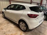 the rear of a white car parked in a garage next to other cars