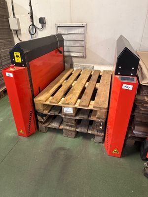 une grosse machine posée sur une palette dans un entrepôt
