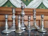 cinq bougeoirs en argent posés sur une table en marbre