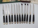 six knives that are sitting on a table next to a box