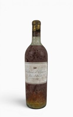 an old bottle of wine sitting on top of a white surface