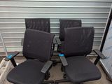 quatre chaises de bureau noires placées devant une porte de garage