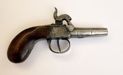 un vieux pistolet avec une poignée en bois sur une surface blanche