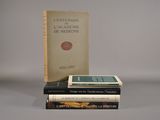 trois livres sont empilés sur une table