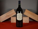 a bottle of wine sitting on a table next to two wooden boxes