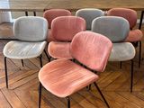 Plusieurs chaises sont alignées en rangée sur un plancher en bois