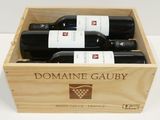 trois bouteilles de vin dans un coffret en bois sur une table