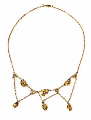 a close up of a gold necklace on a white background