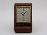 an image of a small wooden clock on a white surface