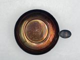 a small metal bowl with a coin in it