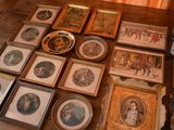 a lot of framed pictures on a table in a room