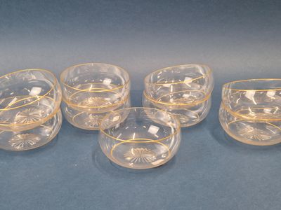 six verres transparents à bord doré sur fond bleu
