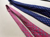 four different colored ties laid out on a white surface