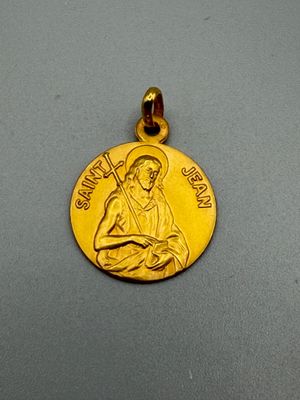 un gros plan d'une médaille d'or posée sur une surface grise