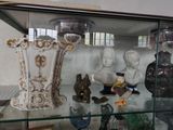 une vitrine en verre contenant de nombreux vases et figurines
