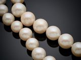 a close up of a strand of pearls on a black surface