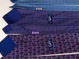 three ties are laid out on a white surface with blue and purple ties